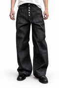 Cinder Indigo Wide — worn on model, wide indigo-black jeans with an exposed button fly over black loafers