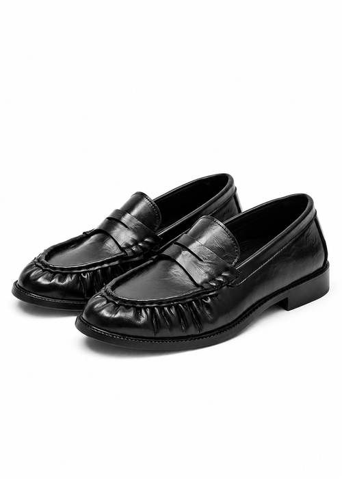 Bracken Loafer — angled view of a pair of black ruched-vamp loafers on a flat sole